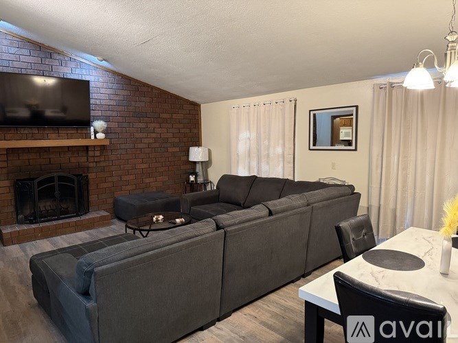 A living room with a grey couch and a fireplace.