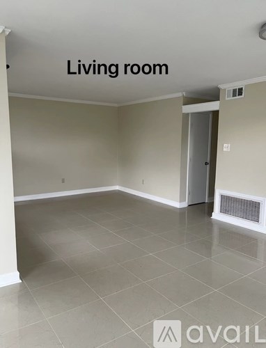 A living room with tile flooring and a doorway leading to another room.