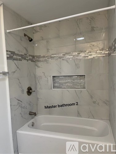 A bathroom with marble walls and a tub labeled "Master bathroom 2".