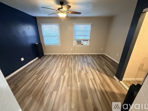 A room with wooden flooring and a ceiling fan.