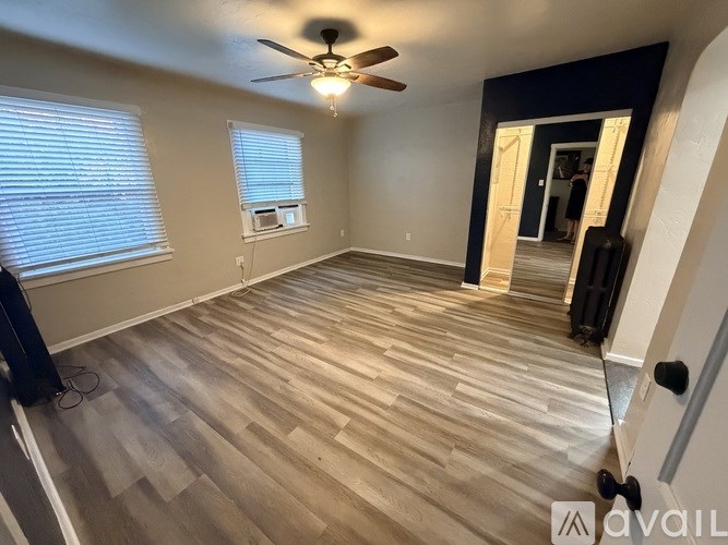 A room with wooden flooring and a ceiling fan.