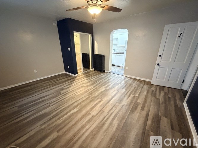 A room with wooden flooring and a ceiling fan.