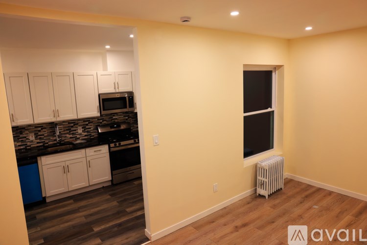A kitchen with a blue cabinet and a window with a white radiator.