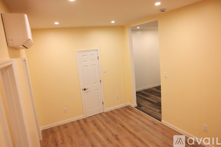 A room with a white door and a window with blinds.