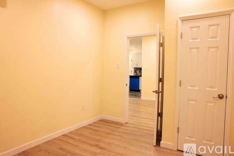 A room with a white door and a white wall.