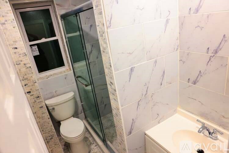 A bathroom with a toilet, sink, and shower.