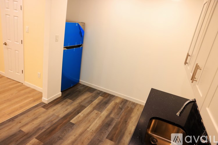 A kitchen area with a sink and a blue fridge.