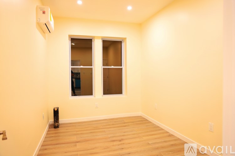 A room with a window and a wall-mounted air conditioner.
