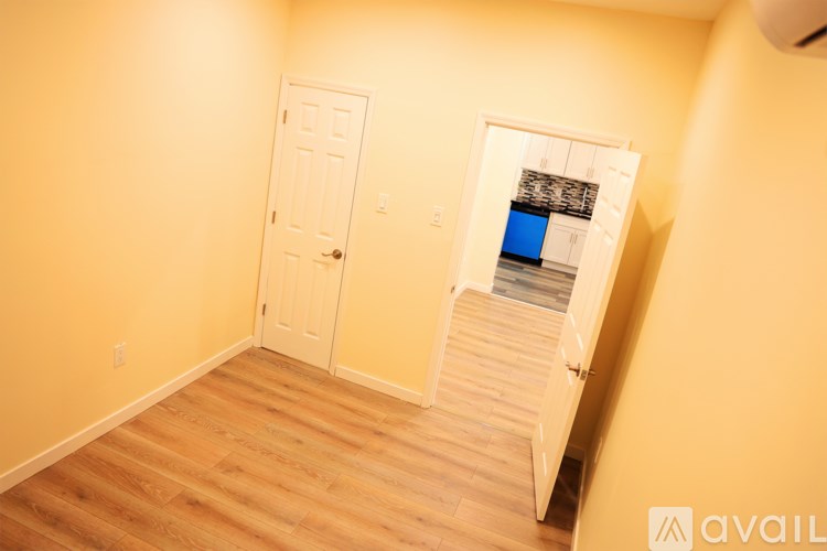 A room with a white door and a staircase leading to a balcony.