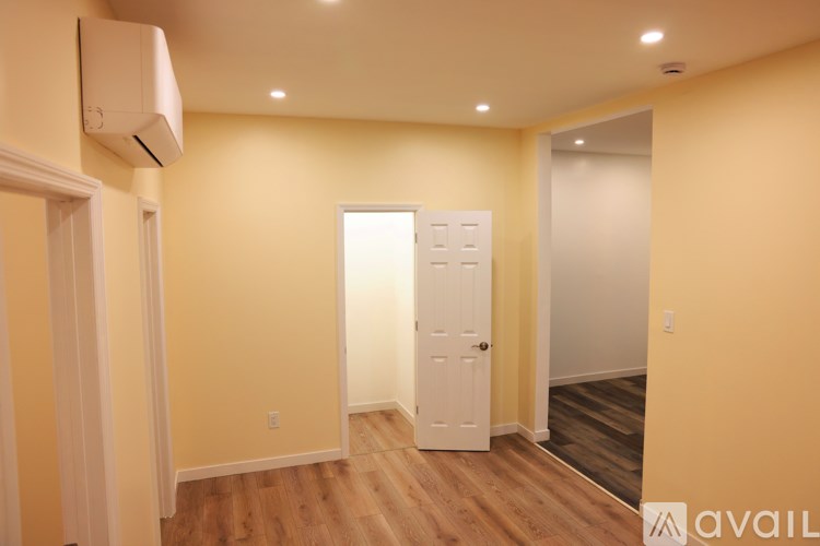 A room with a white door and a window with blinds.