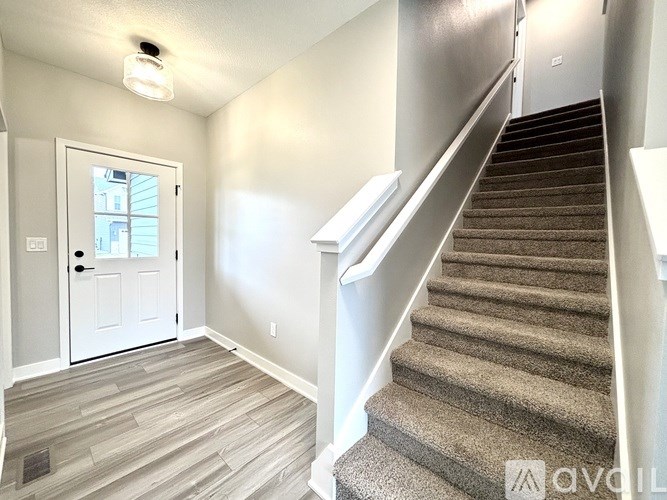 A staircase with a carpeted runner and a white railing.