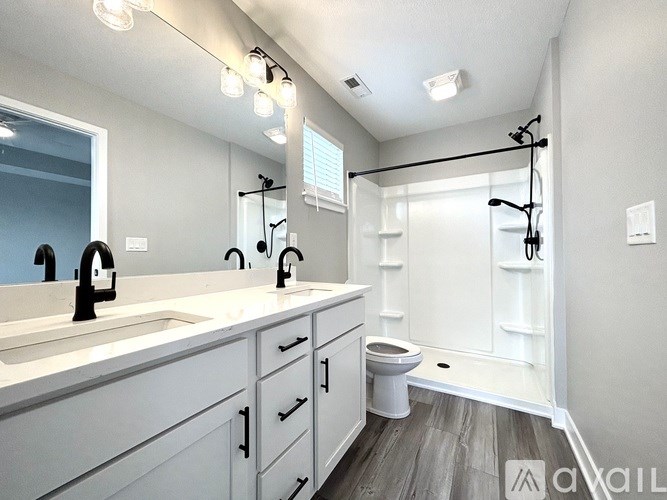 A bathroom with a toilet, sink, and mirror.