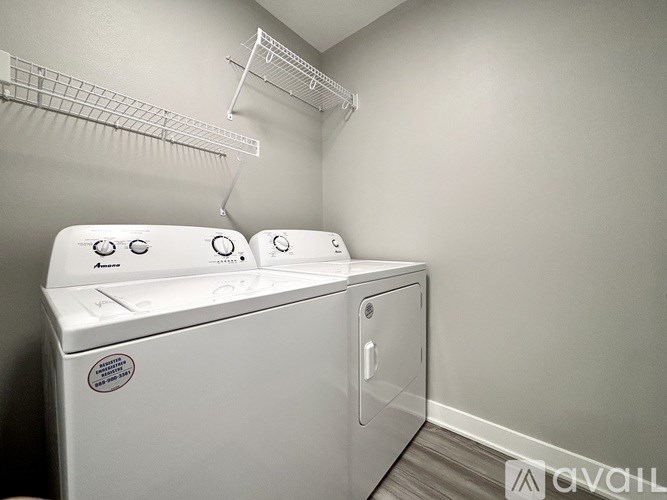 A white washing machine and dryer in a laundry room.