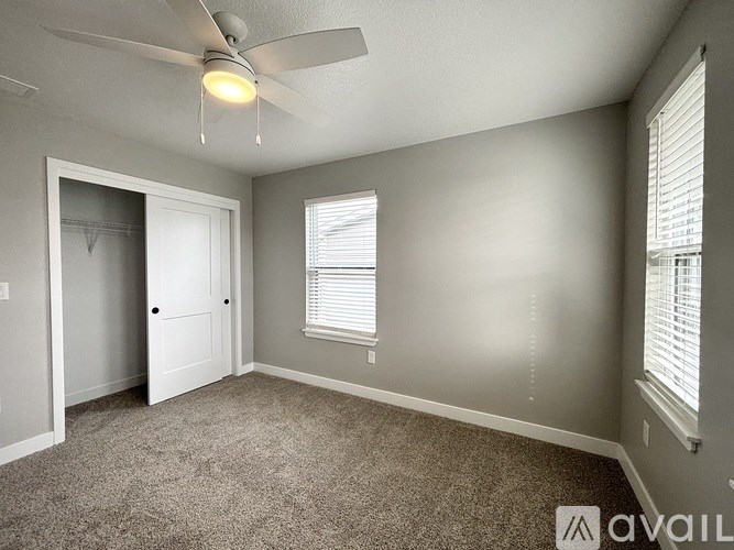 A room with a ceiling fan and carpeted floor.