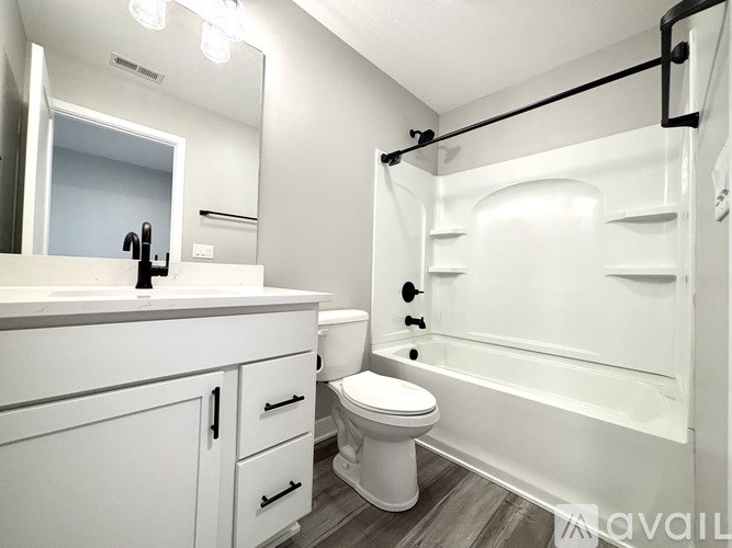 A white bathroom with a toilet, sink, and bathtub.