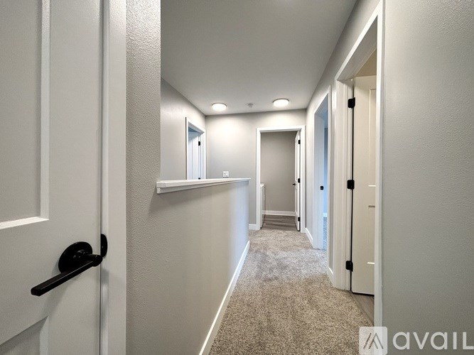 A hallway with white walls and a carpeted floor.