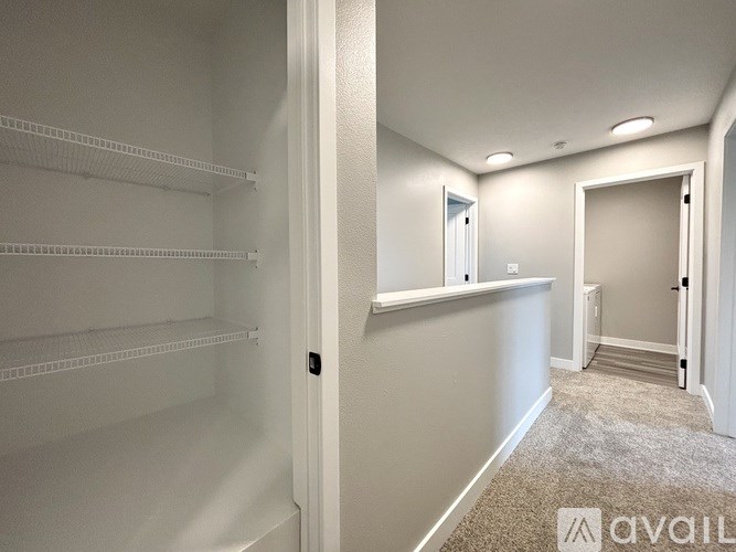 A white refrigerator in a room with a carpeted floor and white walls.