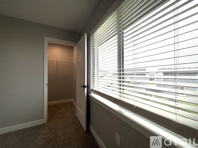 A room with a carpeted floor and a door leading to another room.