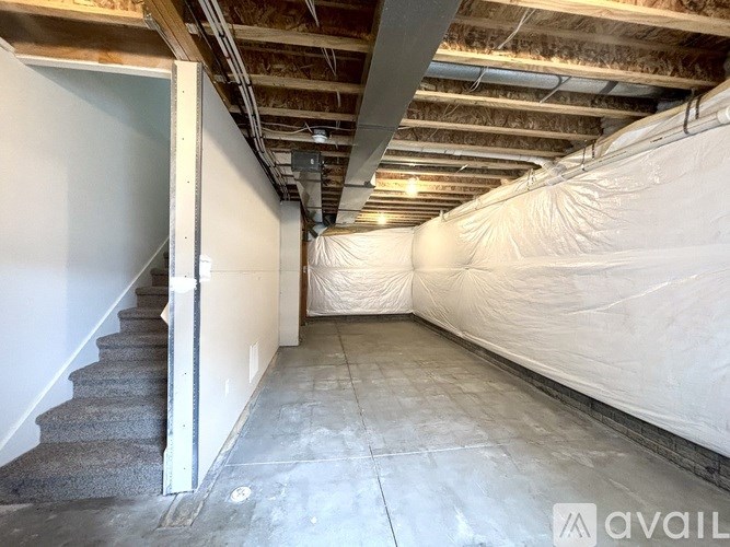 A room with a staircase covered in white insulation material.