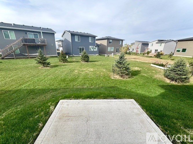 A view from the back of a house looking out over a green lawn.