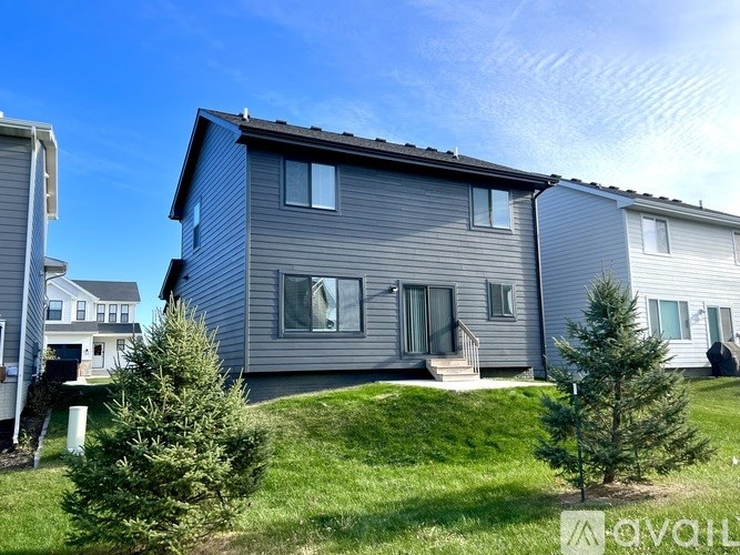A modern house with a grey exterior and a well-maintained lawn.