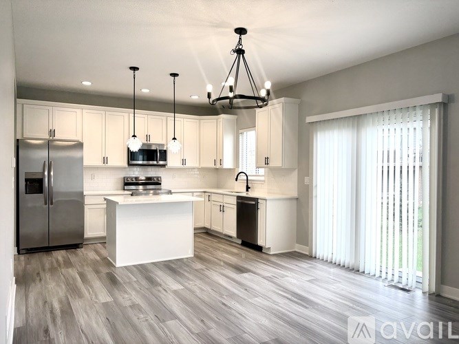 A modern kitchen with a large island and stainless steel appliances.