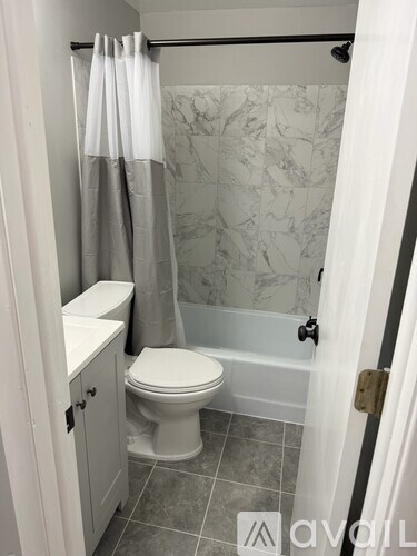 A bathroom with a toilet, sink, and shower.