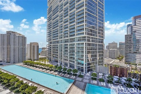 A tall building with a pool in front of it.