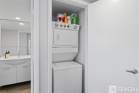 A white kitchen with a stove and oven built into a wall.