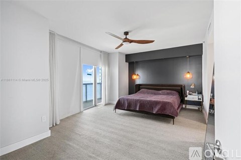 A bedroom with a bed, nightstand, and ceiling fan.