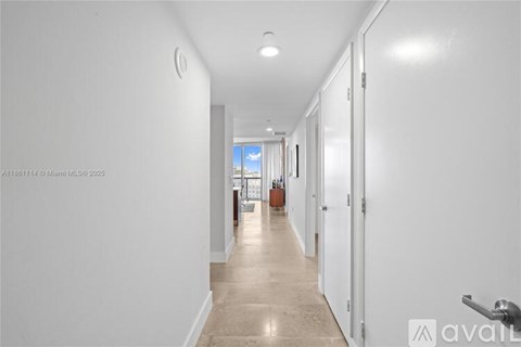 A long hallway with white walls and doors on both sides.