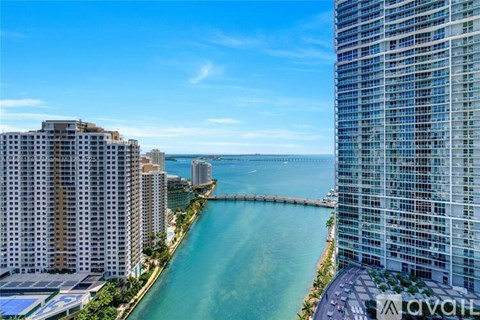 A view of a cityscape with a body of water in between two buildings.