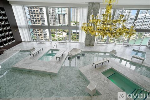 A large indoor swimming pool with a yellow chandelier hanging from the ceiling.