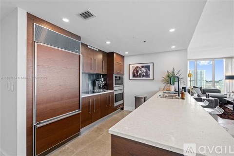 A modern kitchen with a white countertop and wooden cabinets.