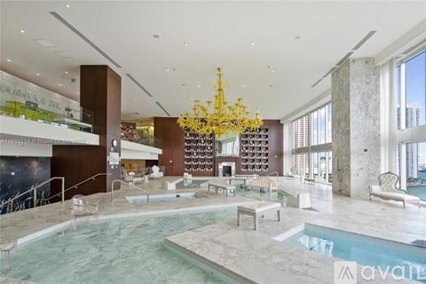 A large indoor swimming pool with a chandelier hanging from the ceiling.