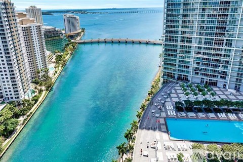 A view of a city with a large body of water and a bridge in the background.