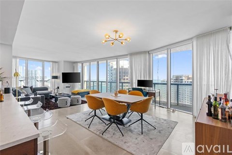 A modern living room with a large table and chairs.