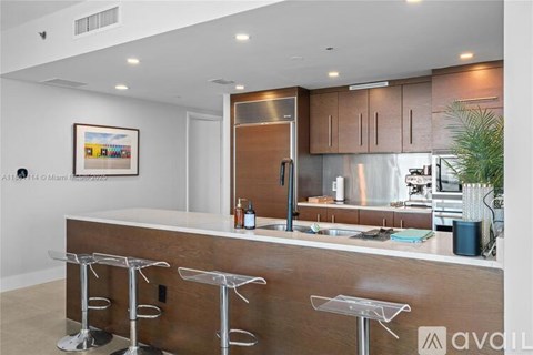 A modern kitchen with a bar area and stools.