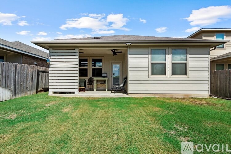 A house with a fence and a lawn in front.