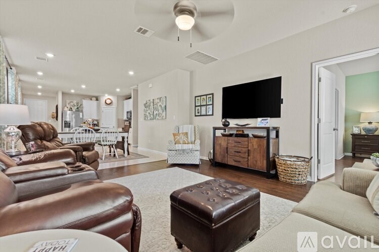 A living room with a brown leather couch and a white rug.