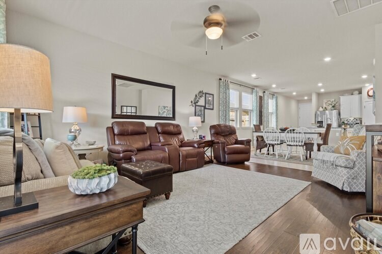 A well-lit living room with a variety of seating options and a large mirror on the wall.