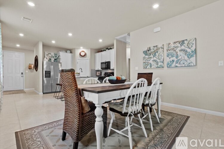 A dining room with a table and chairs.