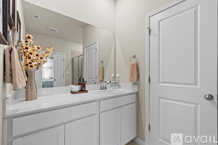 A bathroom with a white vanity and a white door.