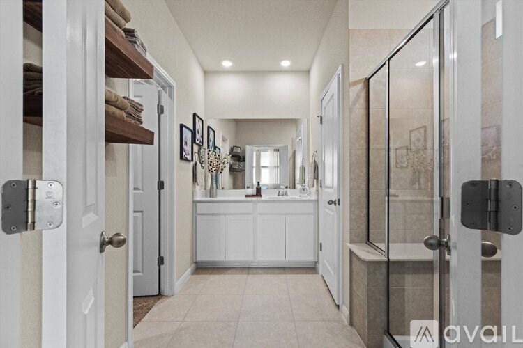 A bathroom with a walk-in shower and a vanity with a mirror.