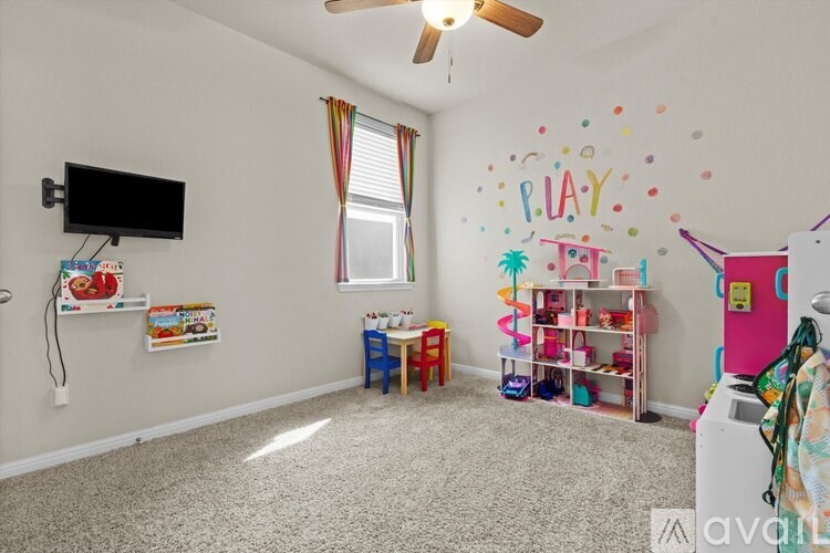 A playroom with a white wall and a ceiling fan.