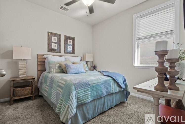 A bedroom with a bed, nightstand, and lamp.