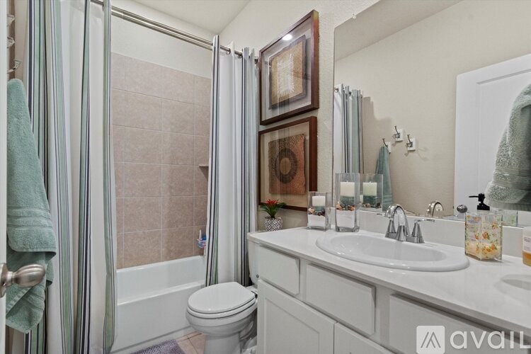 A bathroom with a toilet, sink, and shower.