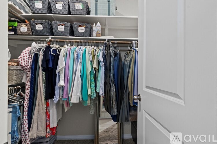 Clothes hanging on a rack in a closet.