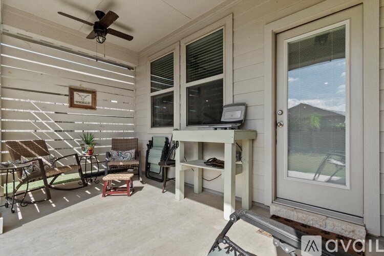 A patio with a table, chairs, and a television.