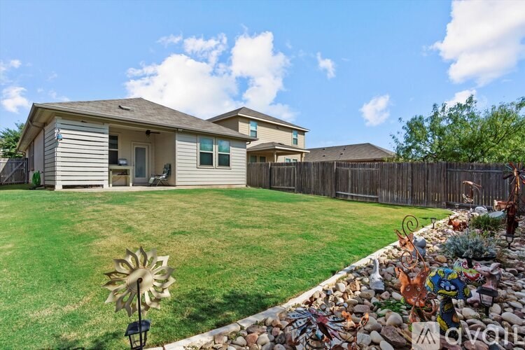 A house with a fence and a garden in front.